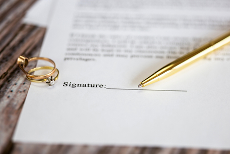 wedding rings, a pen, and a legal document