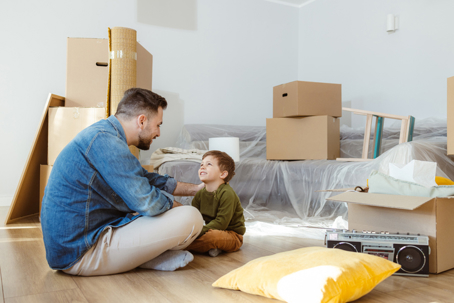 father and son talking while surrounded by moving boxes