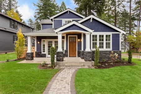 blue house with white accents and stone walkway